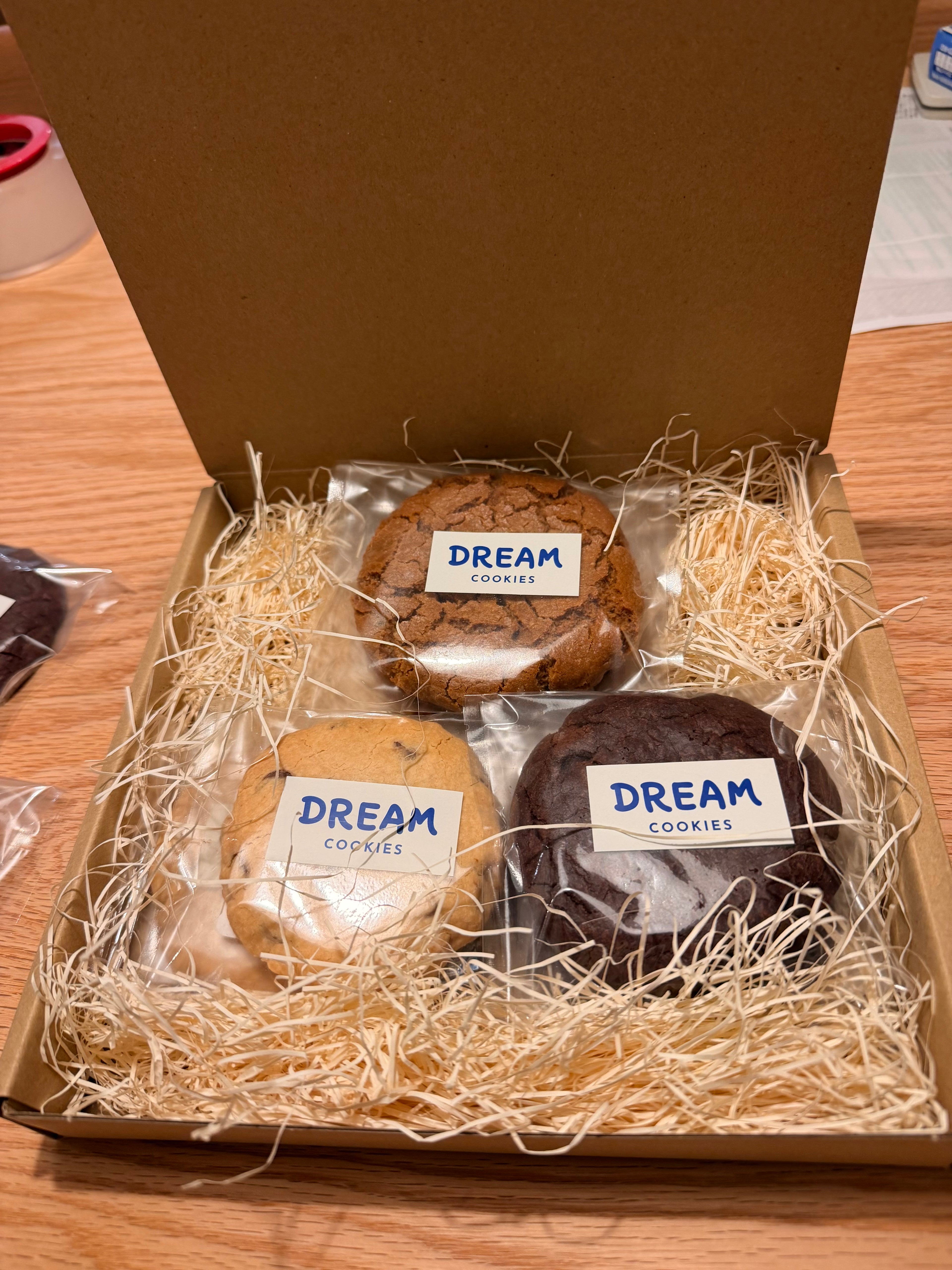 Box of Dream Cookies with three types of cookies on a wooden surface